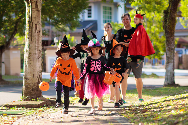 Family trick or treating in Halloween costumes