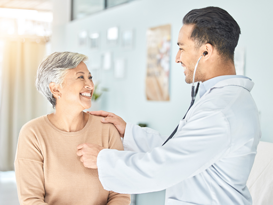 male doctor examining older female patient